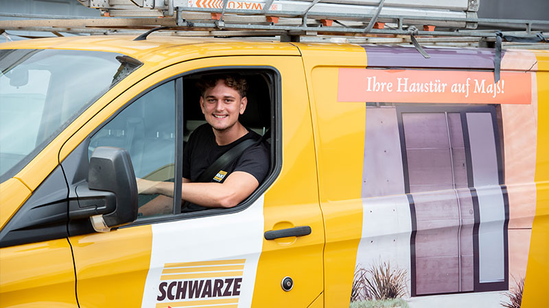 Mitarbeiter sitzt am Steuer eines Montagefahrzeuges