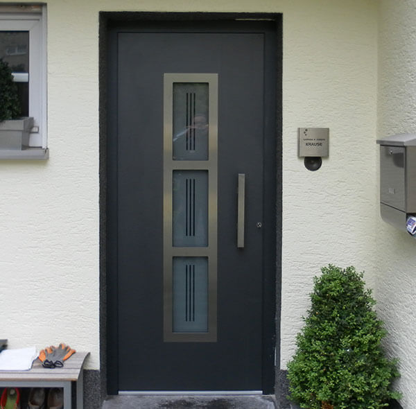 schlichte, elegante Aluminium-Haustür mit eingesetzten Glas-Elementen und Edelstahl Blenden