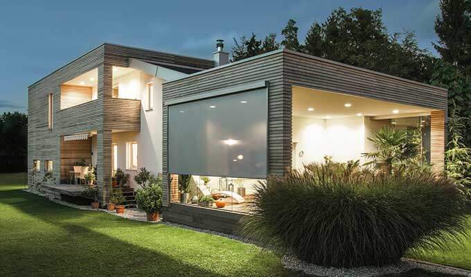 Außenansicht Haus mit grauen Zip-Screens als Sichtschutz an der Terrasse.